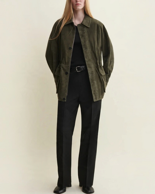 Modèle portant une veste Arma en daim vert foncé avec cordons de serrage, disponible chez Merci Paris
