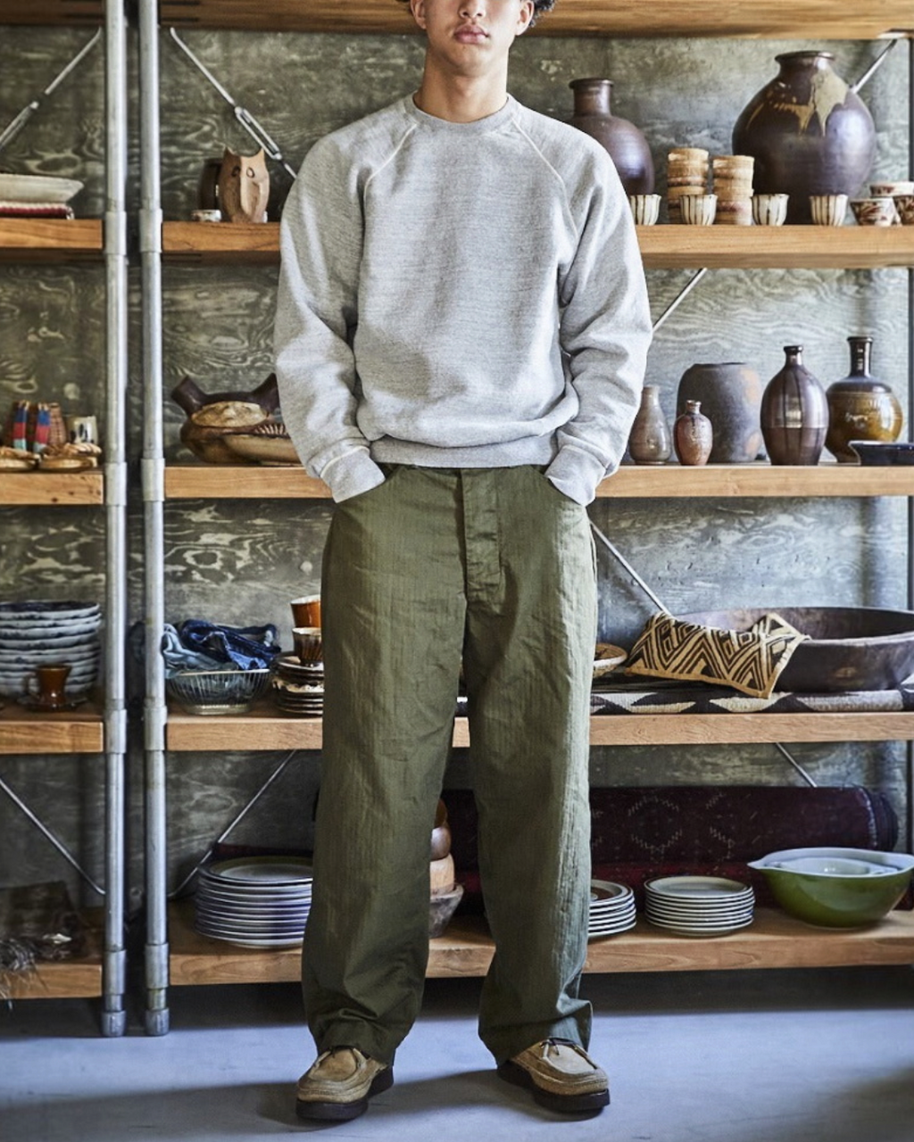 Homme portant le pantalon OrSlow Us Widefit Utility olive en coton chevron, présenté par Merci Paris