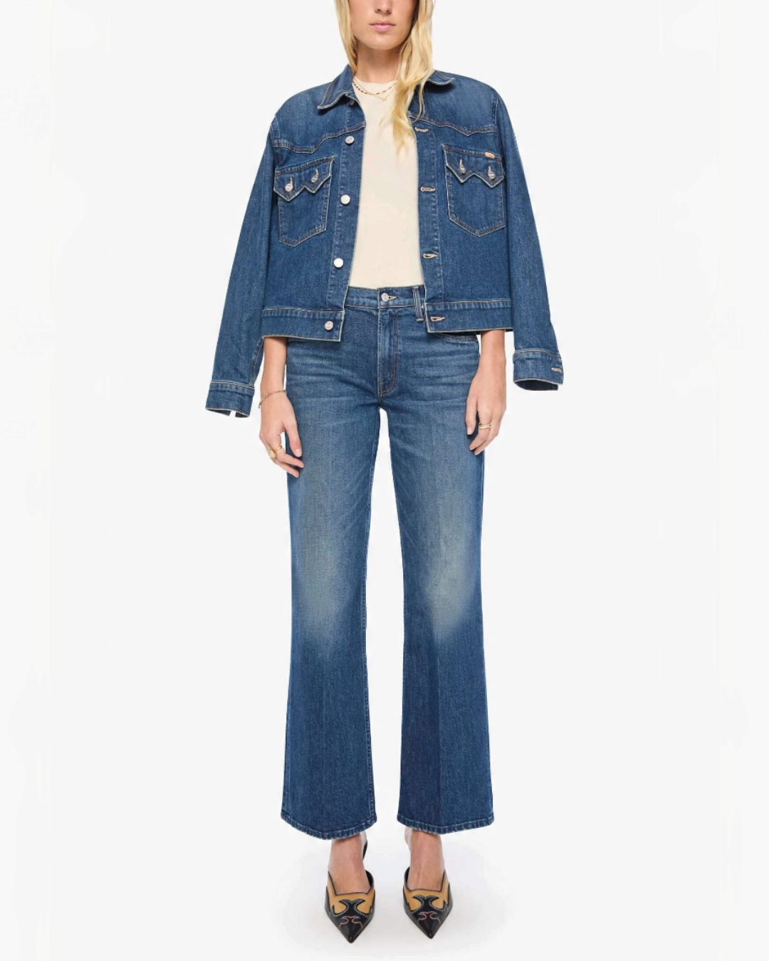 Modèle portant le jean bootcut Merci Paris Mother The Bookie Sneak en denim bleu délavé avec veste assortie