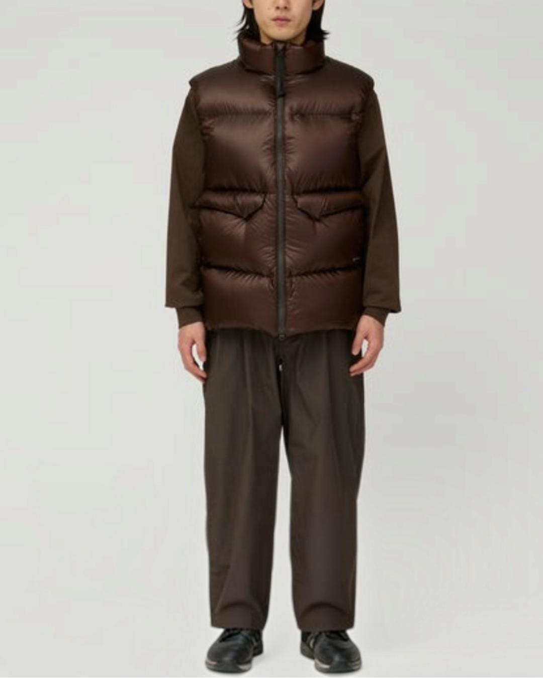 Homme portant une veste sans manches Merci Paris Snow Peak marron foncé en nylon Pertex avec col montant et poches