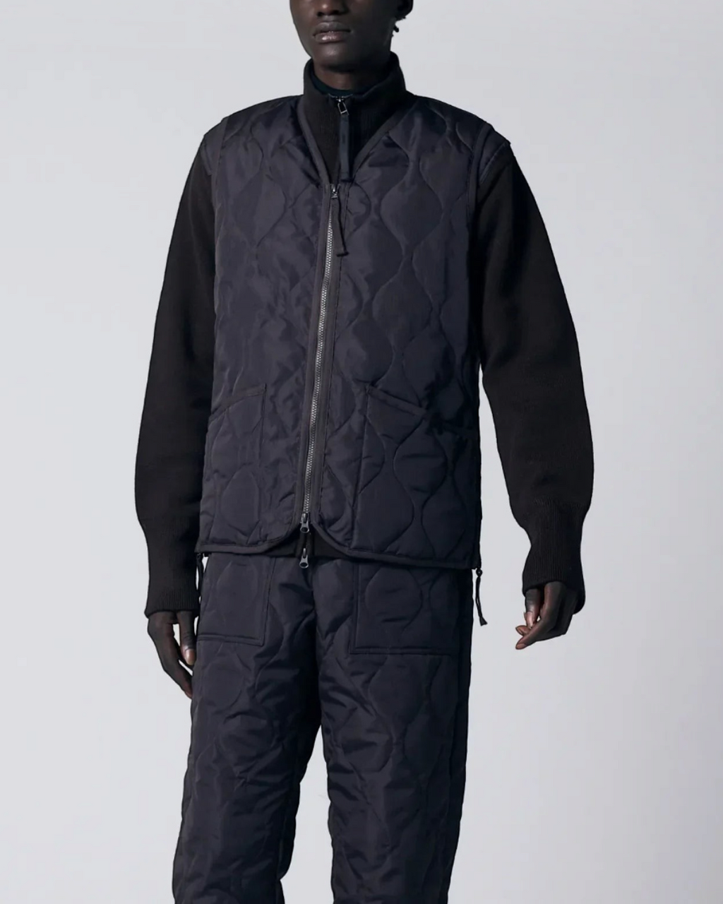 Homme portant un gilet matelassé Merci Paris Taion chocolat à col en V avec fermeture zippée et motif onion