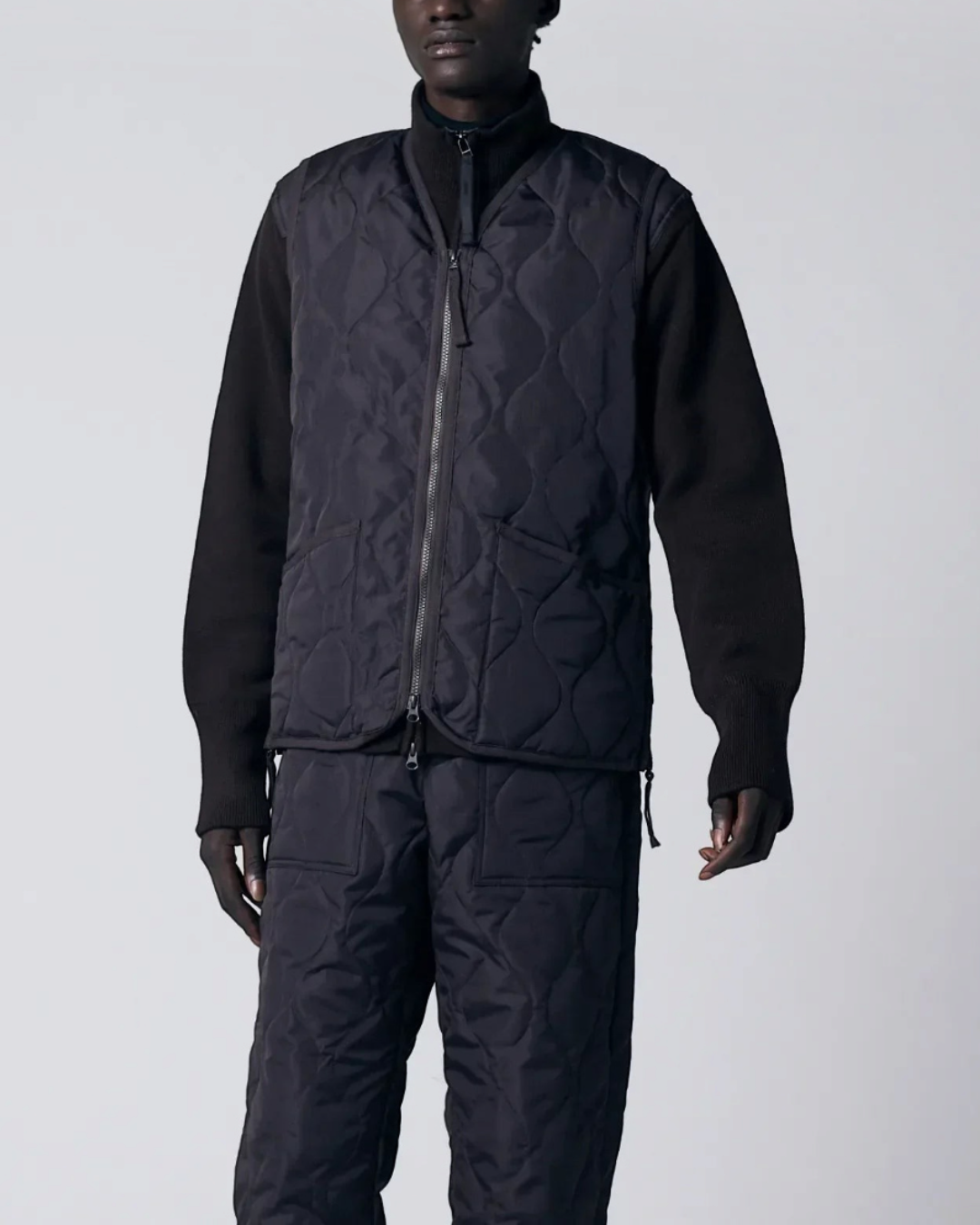 Homme portant un gilet matelassé Merci Paris Taion chocolat à col en V avec fermeture zippée et motif onion