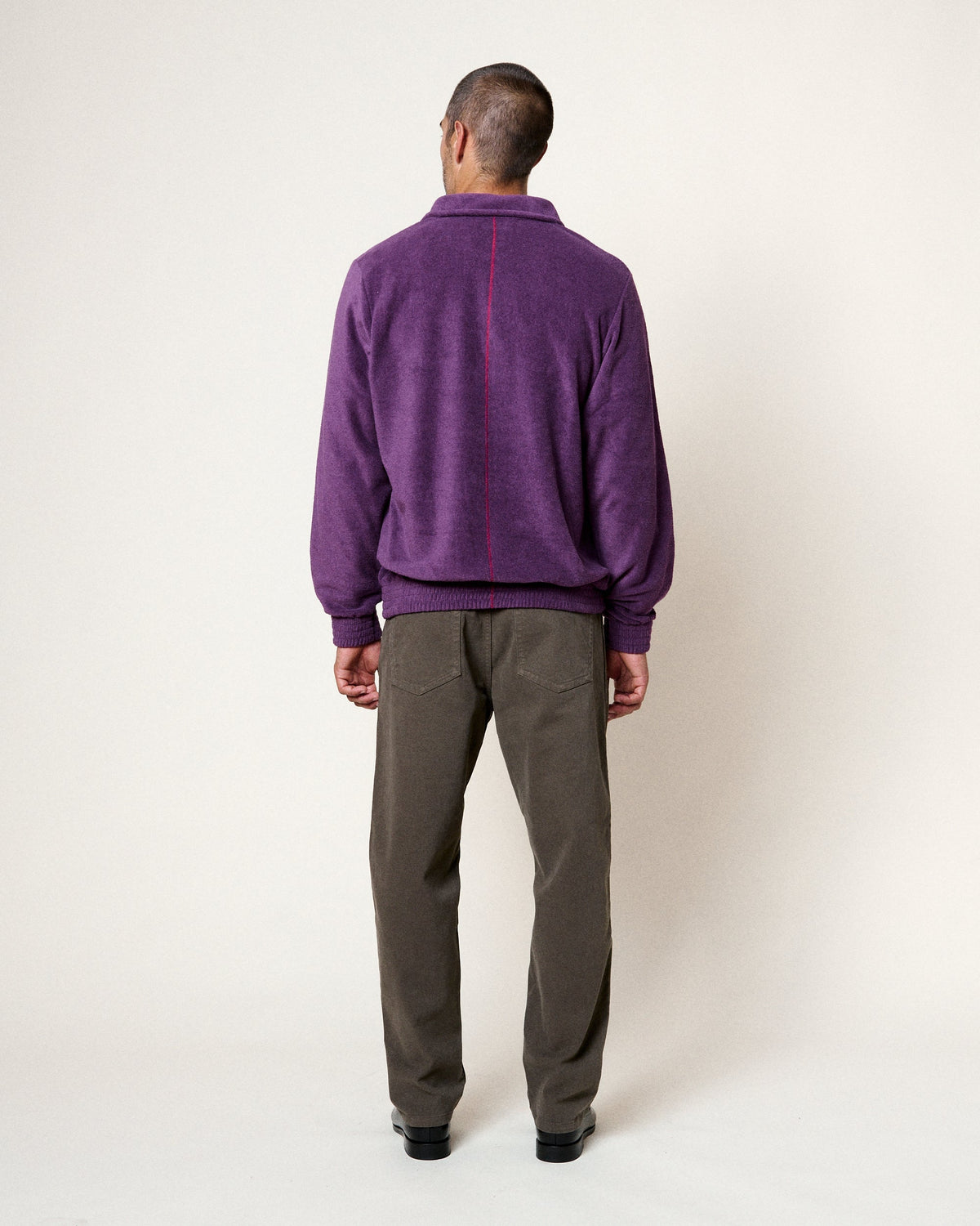 Vue arrière du sweat Homecore Atys violet en texture peluche avec couture rouge signature, porté par un homme