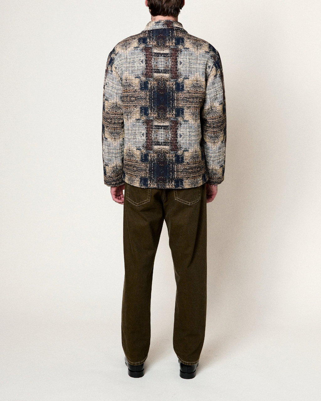 Vue arrière d'un homme portant la veste réversible Homecore Swit Dream en jacquard multi-marron à motif abstrait