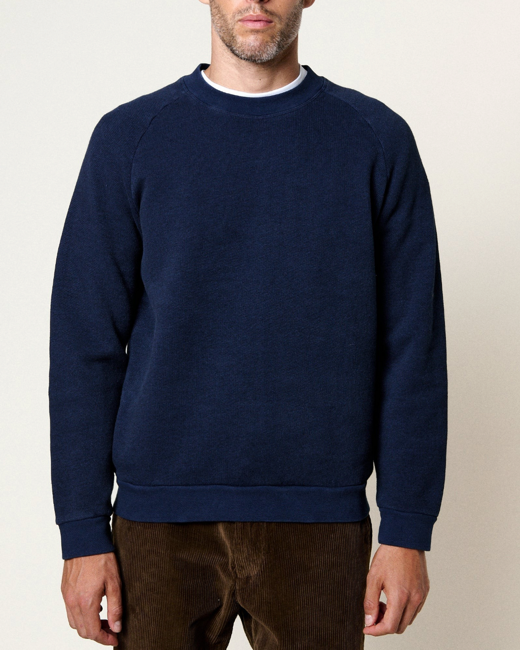Sweatshirt bleu Ocean Homecore avec manches raglan et finitions côtelées porté par un homme, collection Merci Paris