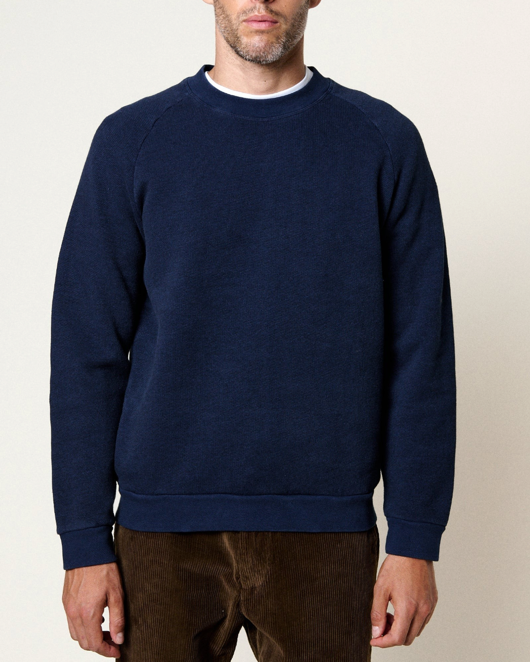 Sweatshirt bleu Ocean Homecore avec manches raglan et finitions côtelées porté par un homme, collection Merci Paris
