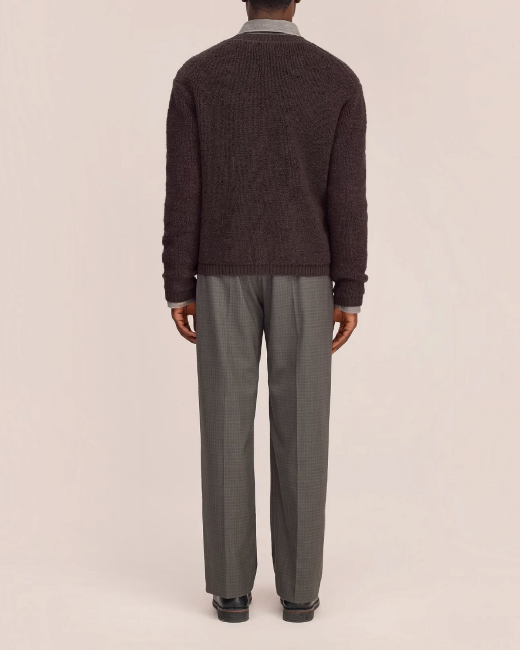 Vue arrière d'un homme portant un cardigan en laine marron NN.07 de Merci Paris sur une chemise et un pantalon gris