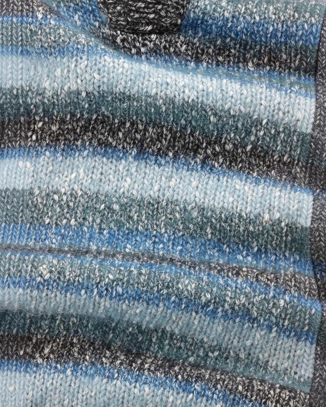Gros plan sur la maille bouclée rayée bleue et noire du polo Erling de Merci Paris en mélange de coton et laine