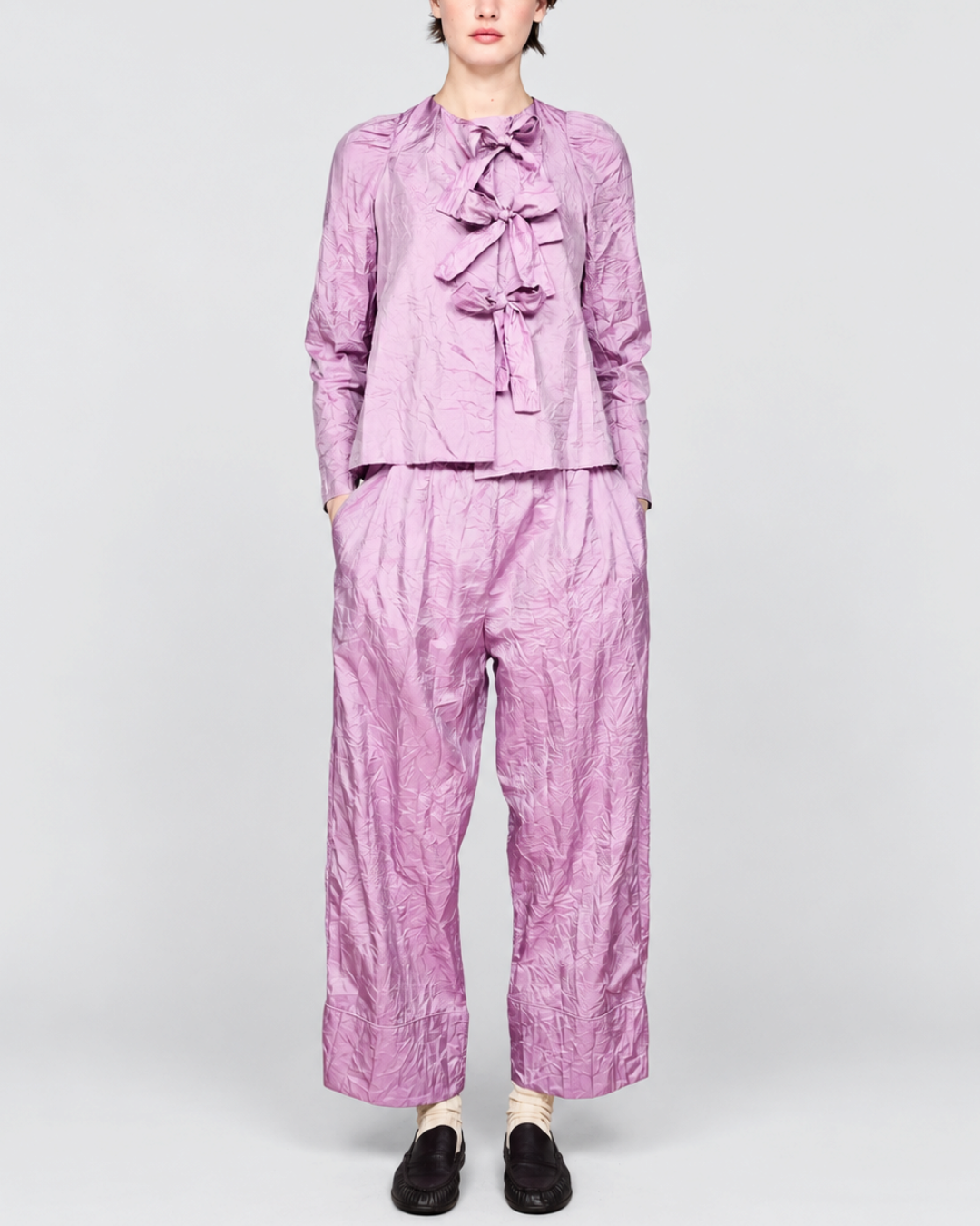 Modèle portant la chemise violette ELEPH à nœuds et pantalon assorti en tissu technique froissé chez Merci Paris