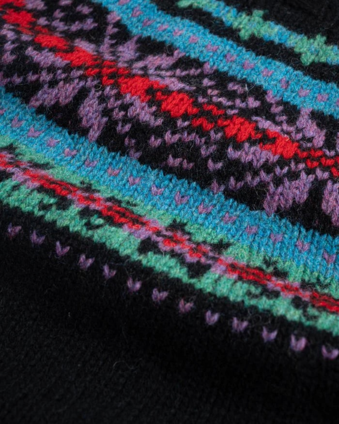 Gros plan sur le pull Merci Paris Howlin' en laine noire avec motif jacquard Fair Isle coloré et texturé