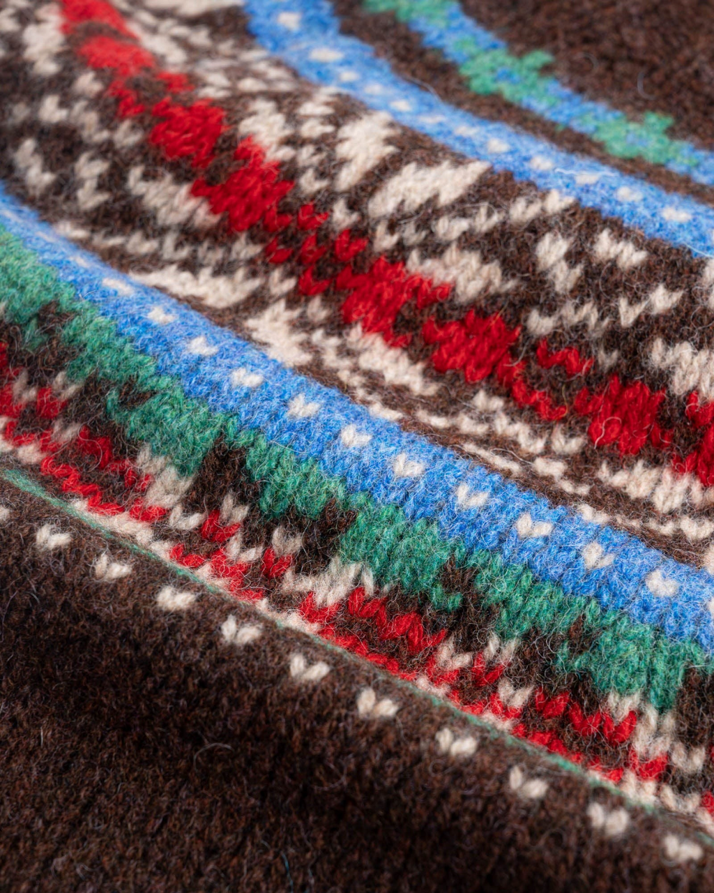 Gros plan sur le pull Merci Paris Howlin' en laine Shetland marron avec motifs jacquard colorés style Fair Isle