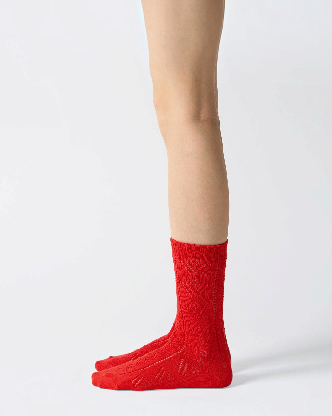 Chaussettes ajourées rouges en laine Babaco portées, style féminin et artisanal, vendues par Merci Paris