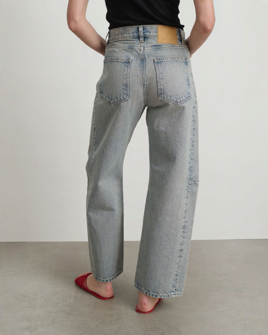 Vue arrière du jean Slim Lasso Merci Paris en denim de coton bleu délavé avec taille haute et coupe incurvée