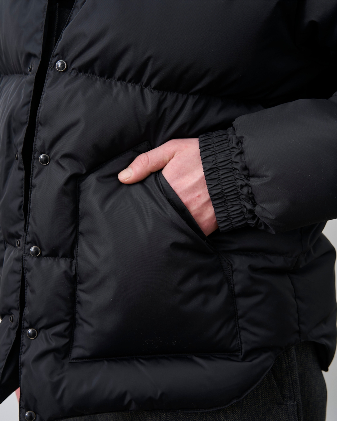 Détail de la poche latérale de la veste noire Merci Paris Rocky Mountain en nylon matelassé avec boutons-pression