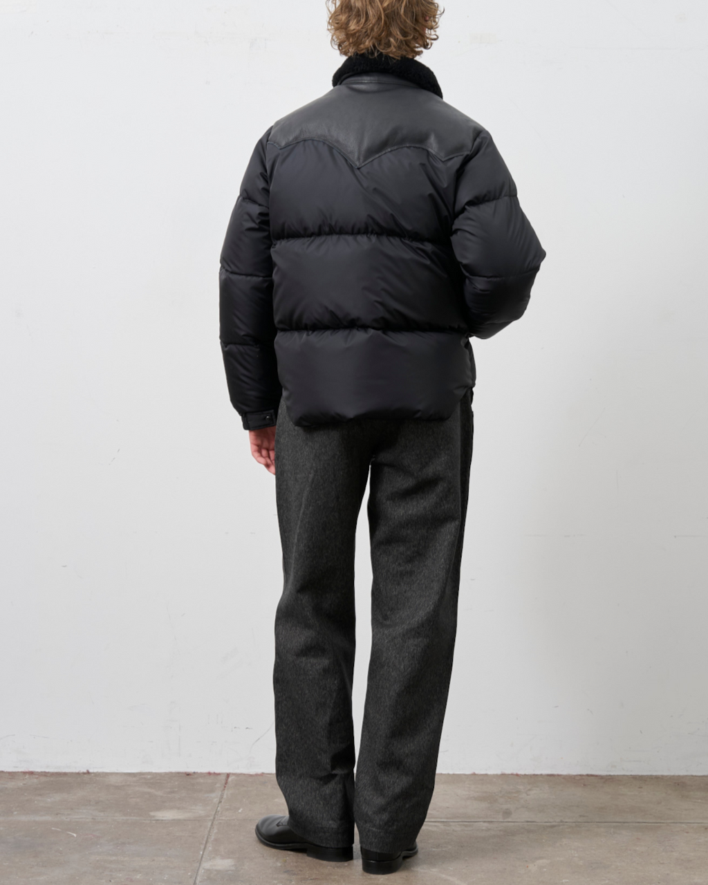 Homme portant la veste noire Rocky Mountain Christy avec empiècement en cuir et col en peau lainée chez Merci Paris