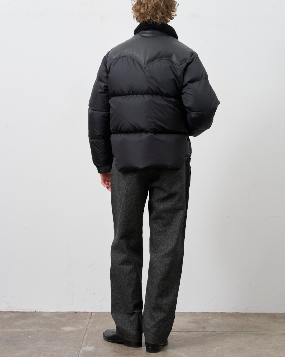 Homme portant la veste noire Rocky Mountain Christy avec empiècement en cuir et col en peau lainée chez Merci Paris