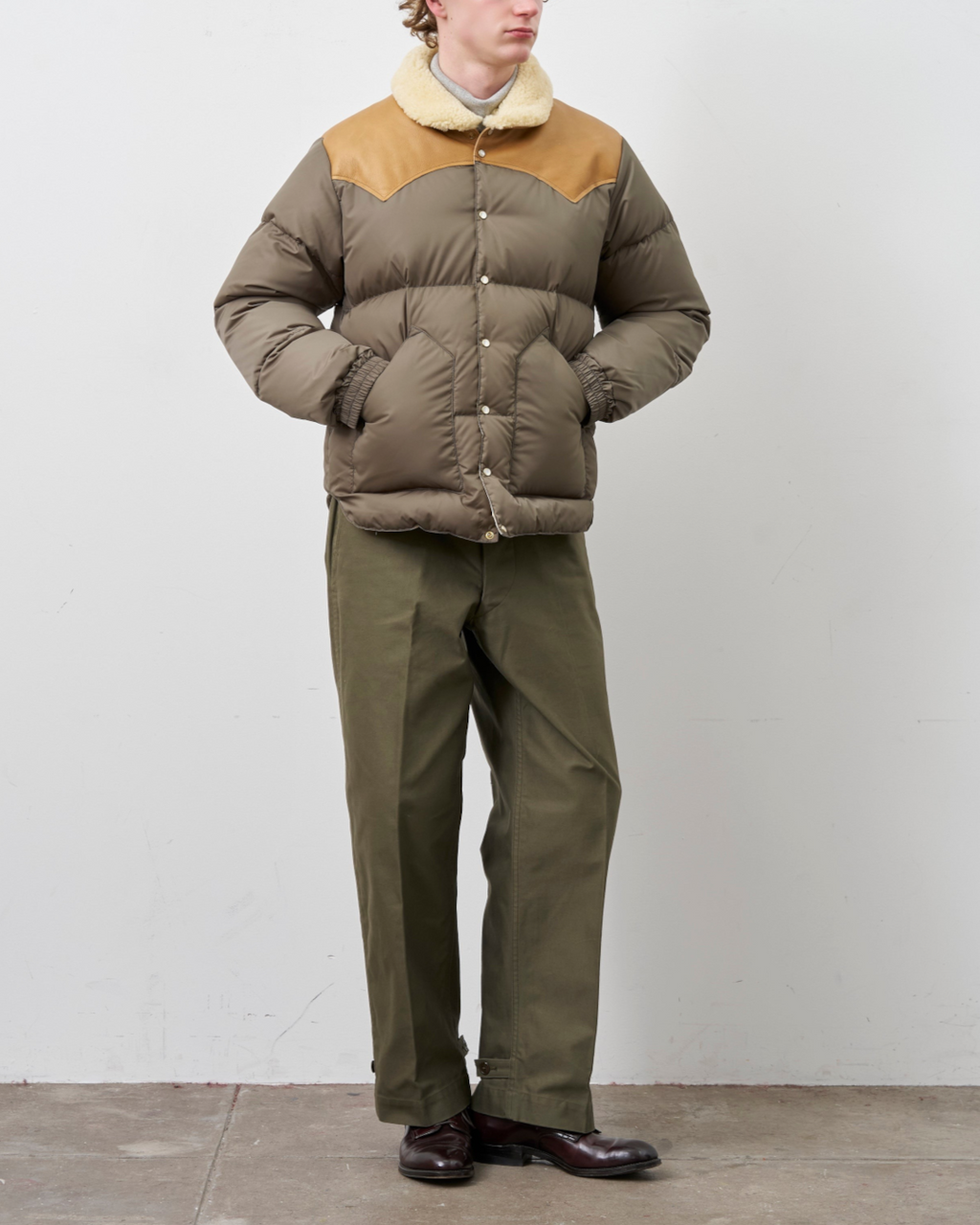 Homme portant une doudoune Merci Paris Rocky Mountain Christy olive avec empiècement en cuir et col en peau lainée