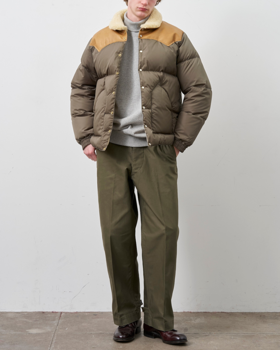 Homme portant la veste Christy Merci Paris en nylon olive avec empiècement en cuir et col en peau lainée