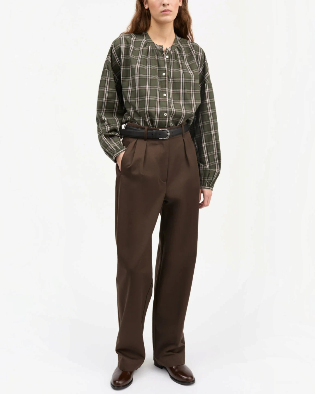 Model wearing shirt Skall Studio Cilla green and white check organic cotton with voluminous sleeves