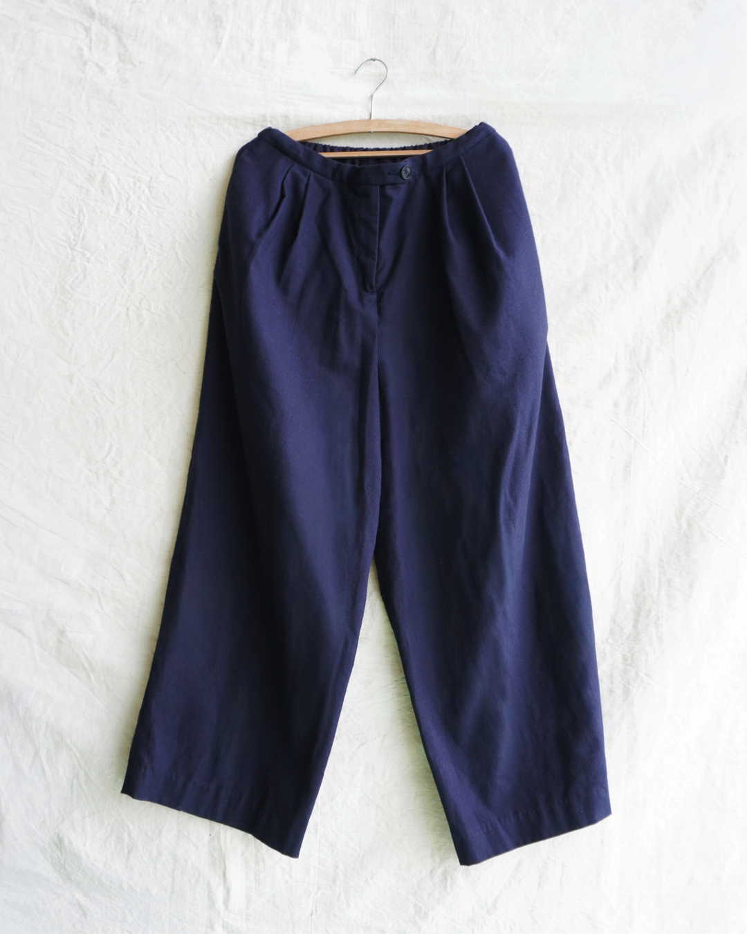 Pantalon large bleu marine Dopple & Scent par Merci Paris avec plis à la taille sur cintre en bois