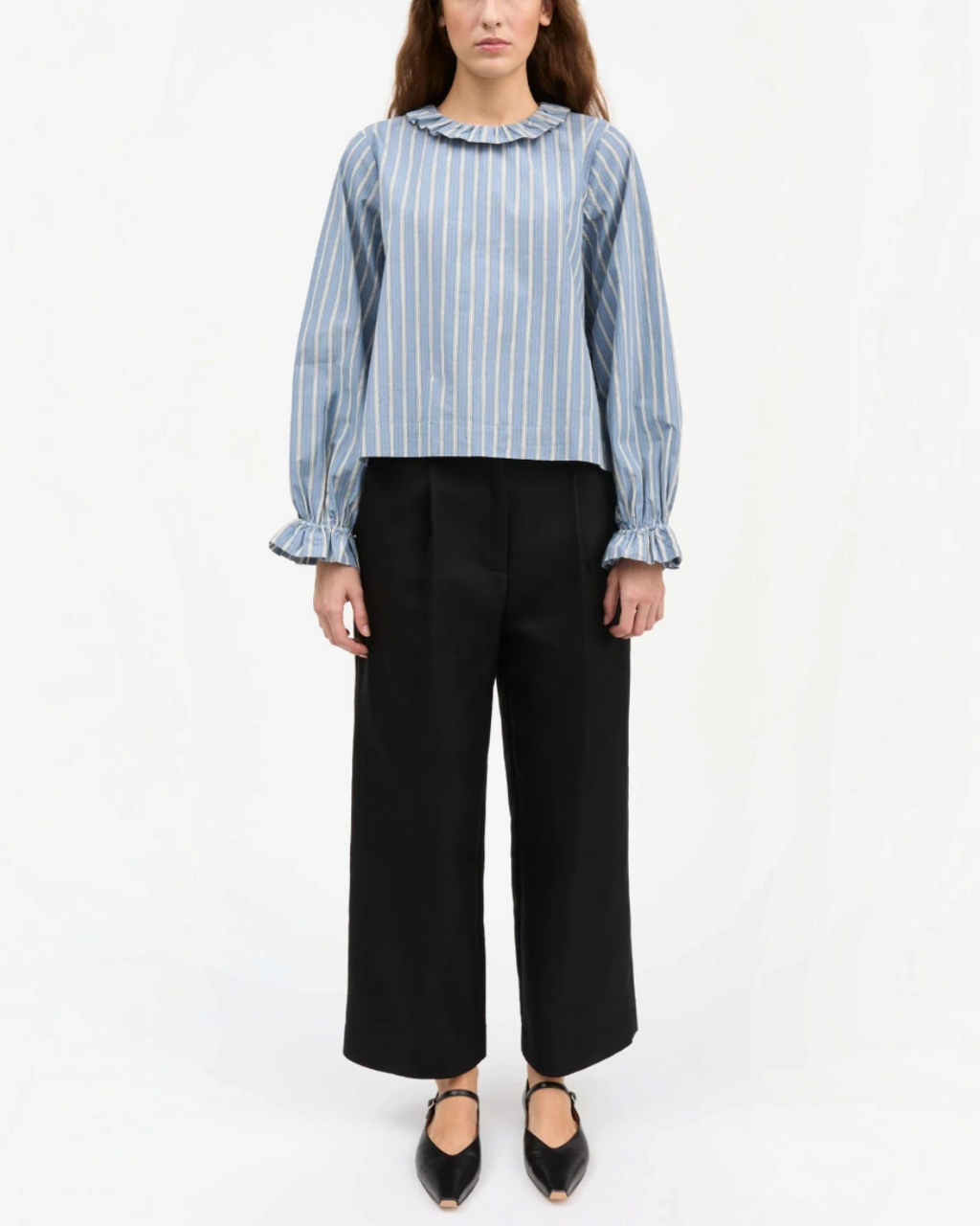 Model wearing Skall Studio organic cotton bleu striped blouse, ruffled round neck and sleeves puffy