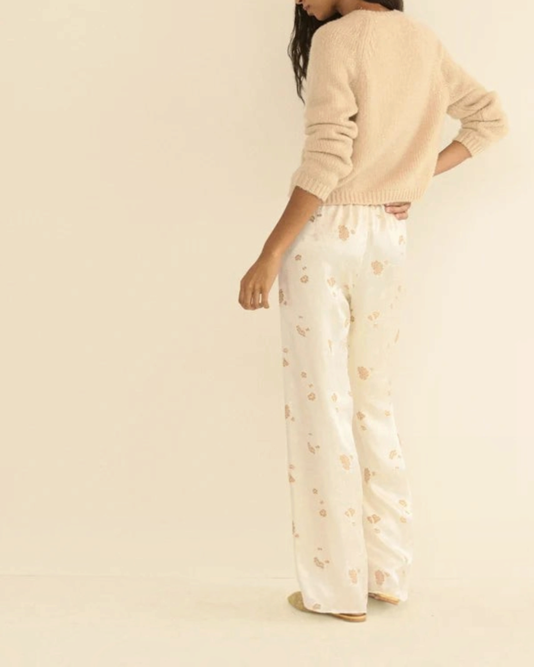 Cardigan Darcy beige en laine et cachemire Merci Paris porté par une femme avec un pantalon fluide à motifs