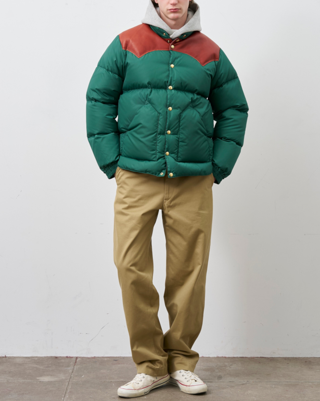 Homme portant une doudoune Merci Paris Rocky Mountain verte avec empiècement en cuir marron sur les épaules