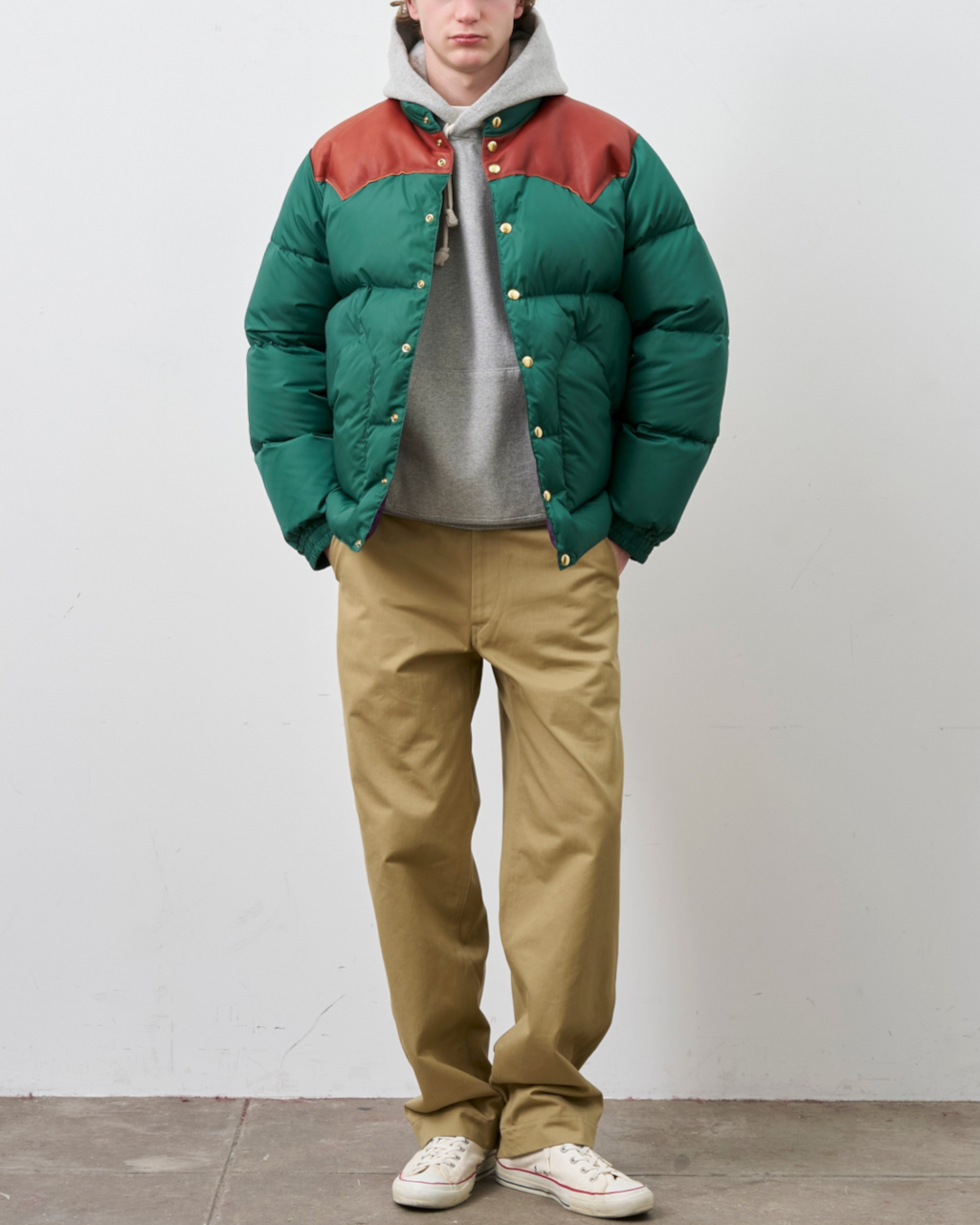 Homme portant une doudoune Merci Paris Rocky Mountain verte avec empiècement en cuir marron sur les épaules