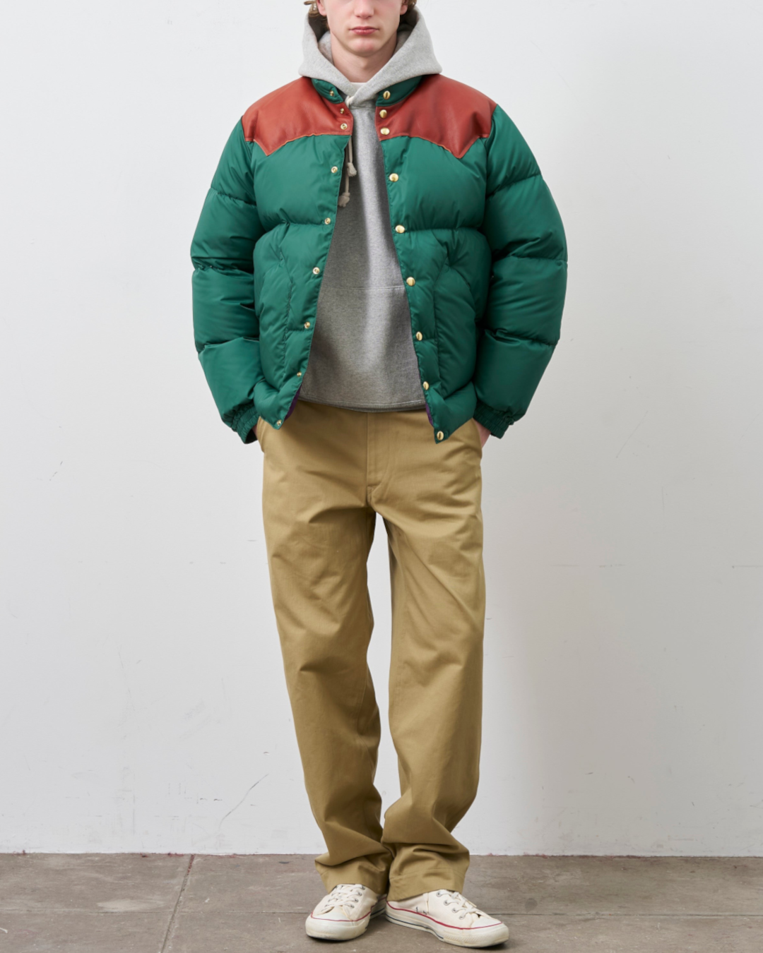 Homme portant une doudoune Merci Paris Rocky Mountain verte avec empiècement en cuir marron sur les épaules