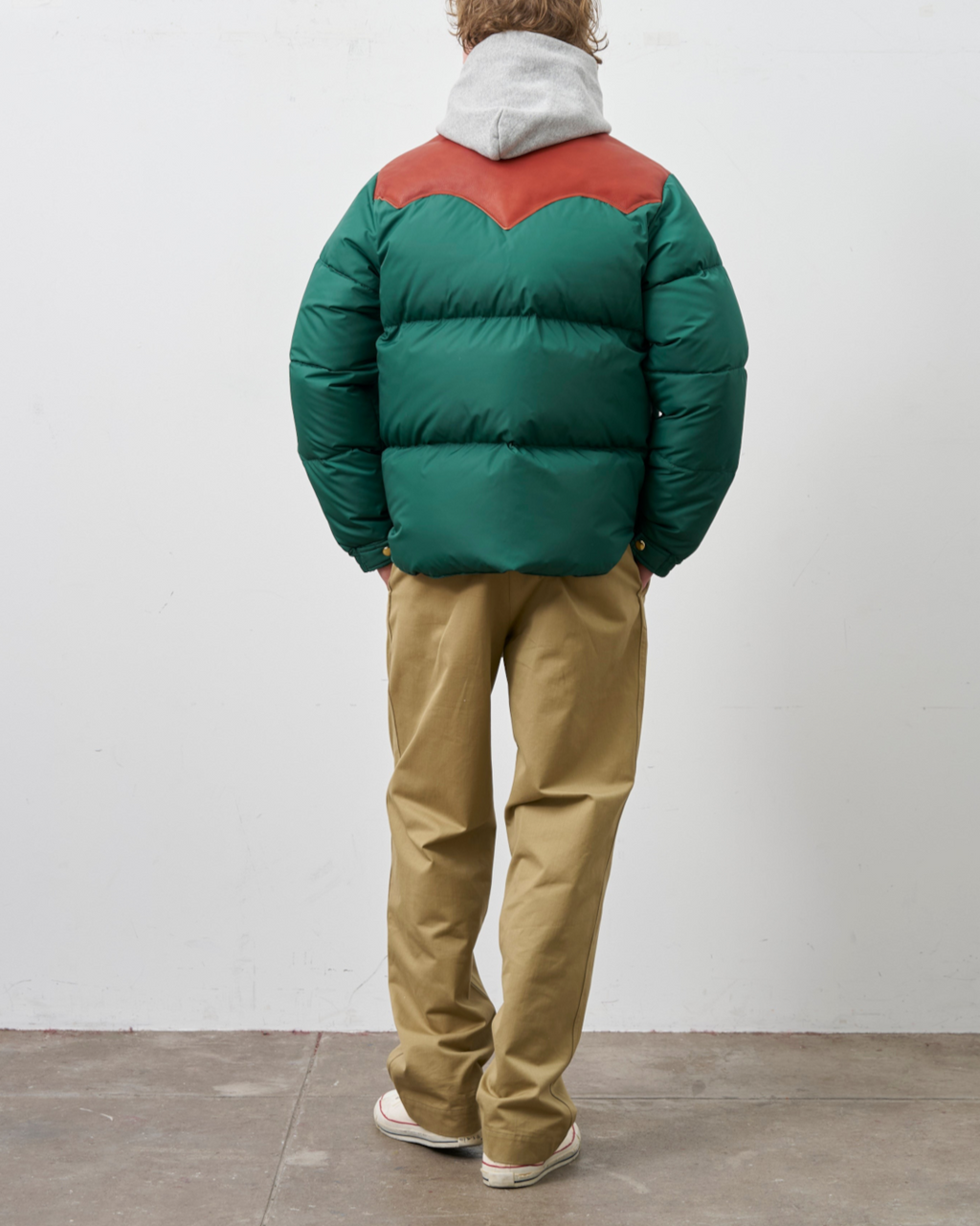 Homme portant une doudoune Merci Paris Rocky Mountain verte avec empiècement en cuir marron sur les épaules
