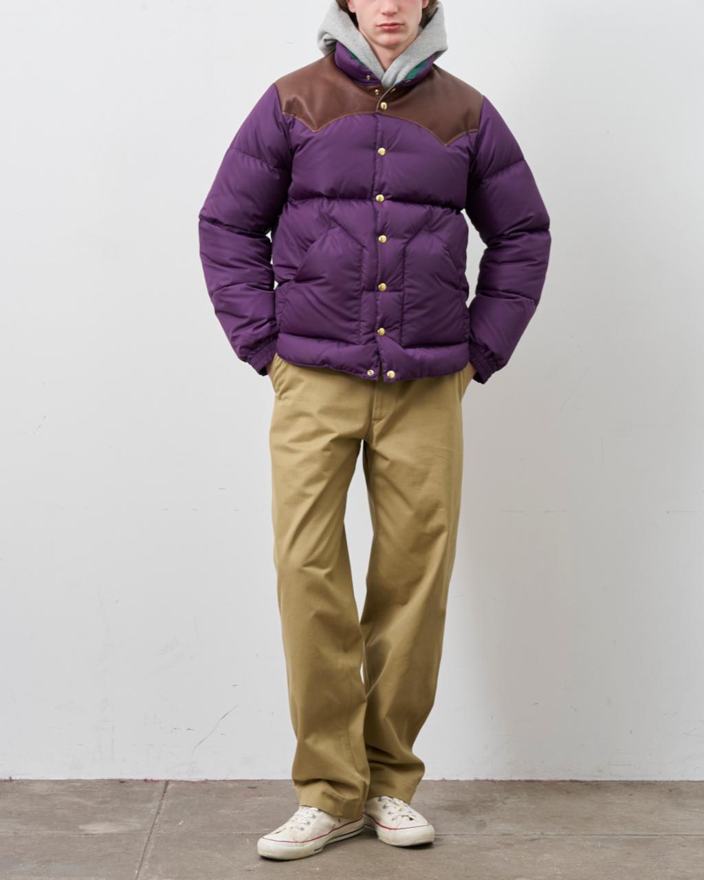 Homme portant une veste en duvet Merci Paris Rocky Mountain violette avec empiècement en cuir marron sur les épaules