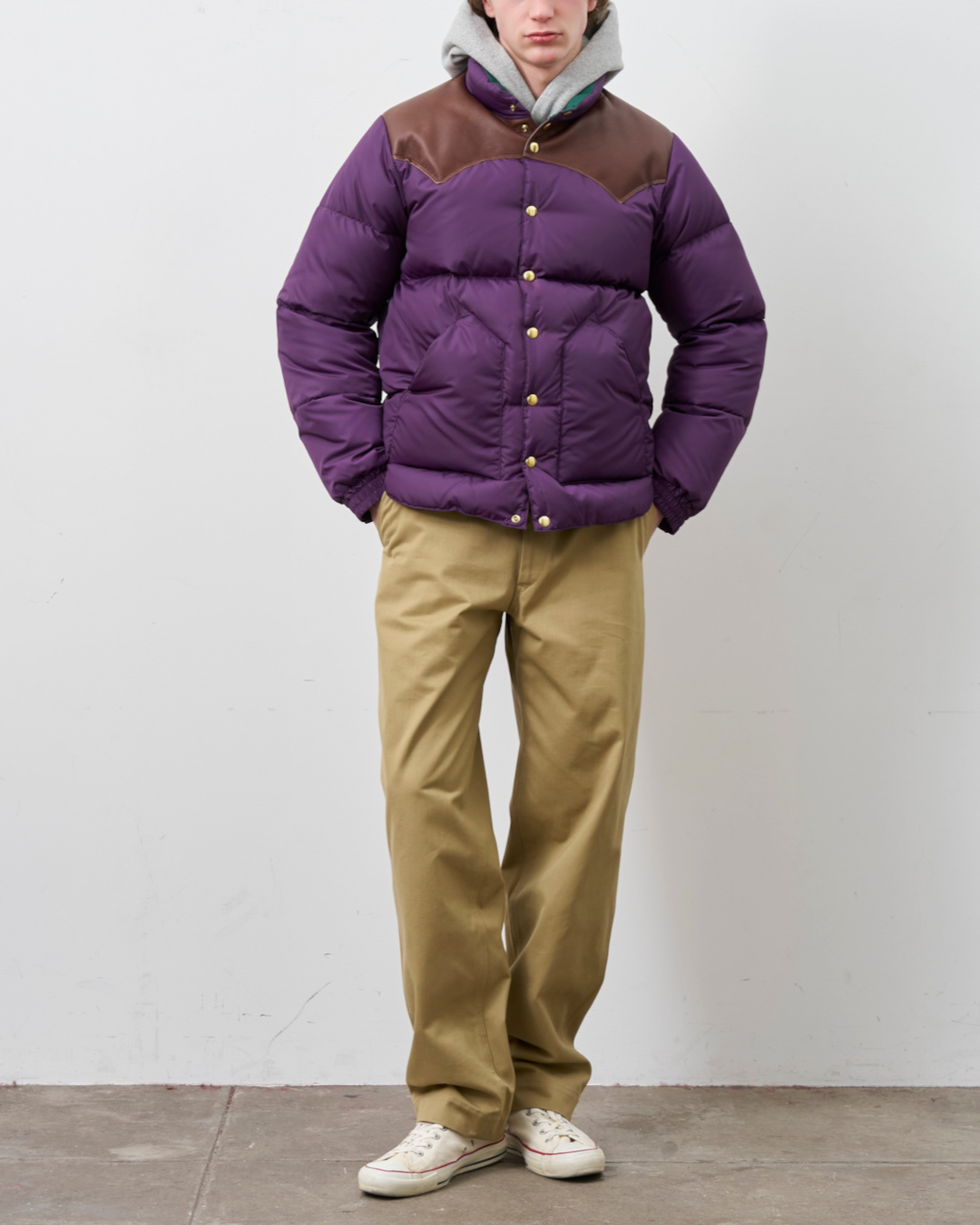 Homme portant une veste en duvet Merci Paris Rocky Mountain violette avec empiècement en cuir marron sur les épaules