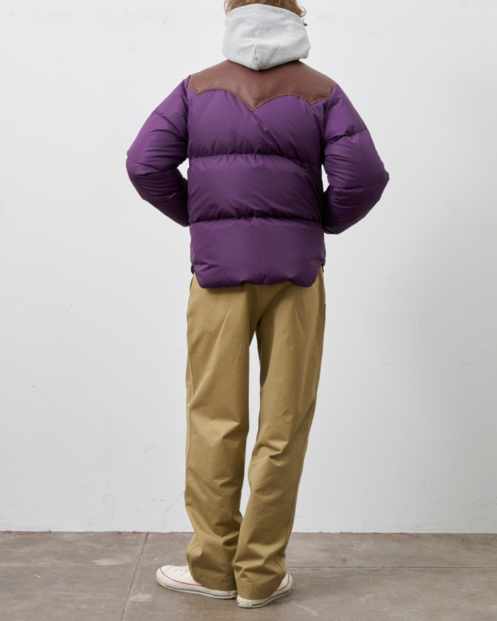 Homme portant une doudoune Merci Paris Rocky Mountain violette avec empiècement en cuir marron, vue de dos