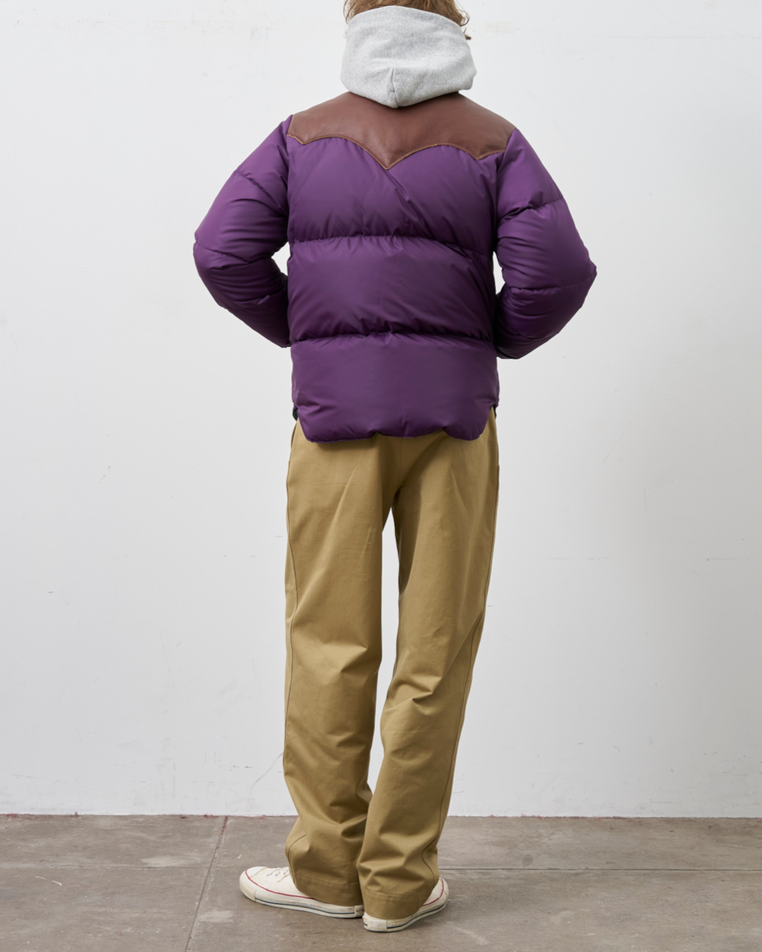 Homme portant une doudoune Merci Paris Rocky Mountain violette avec empiècement en cuir marron, vue de dos