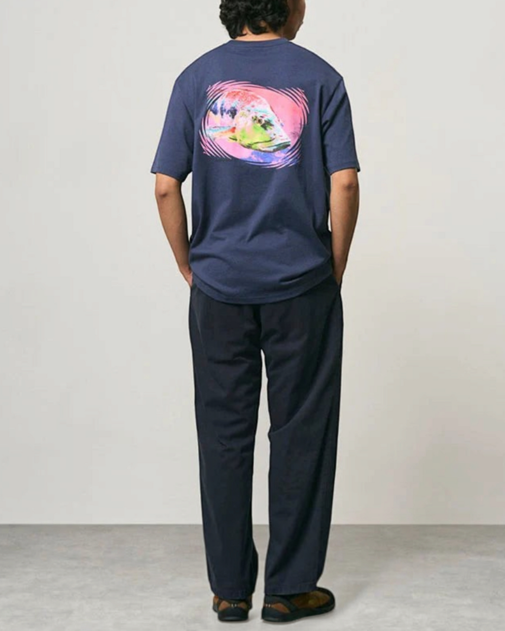 Homme portant un pantalon droit bleu marine Merci Paris Gramicci en coton avec un t-shirt graphique au dos