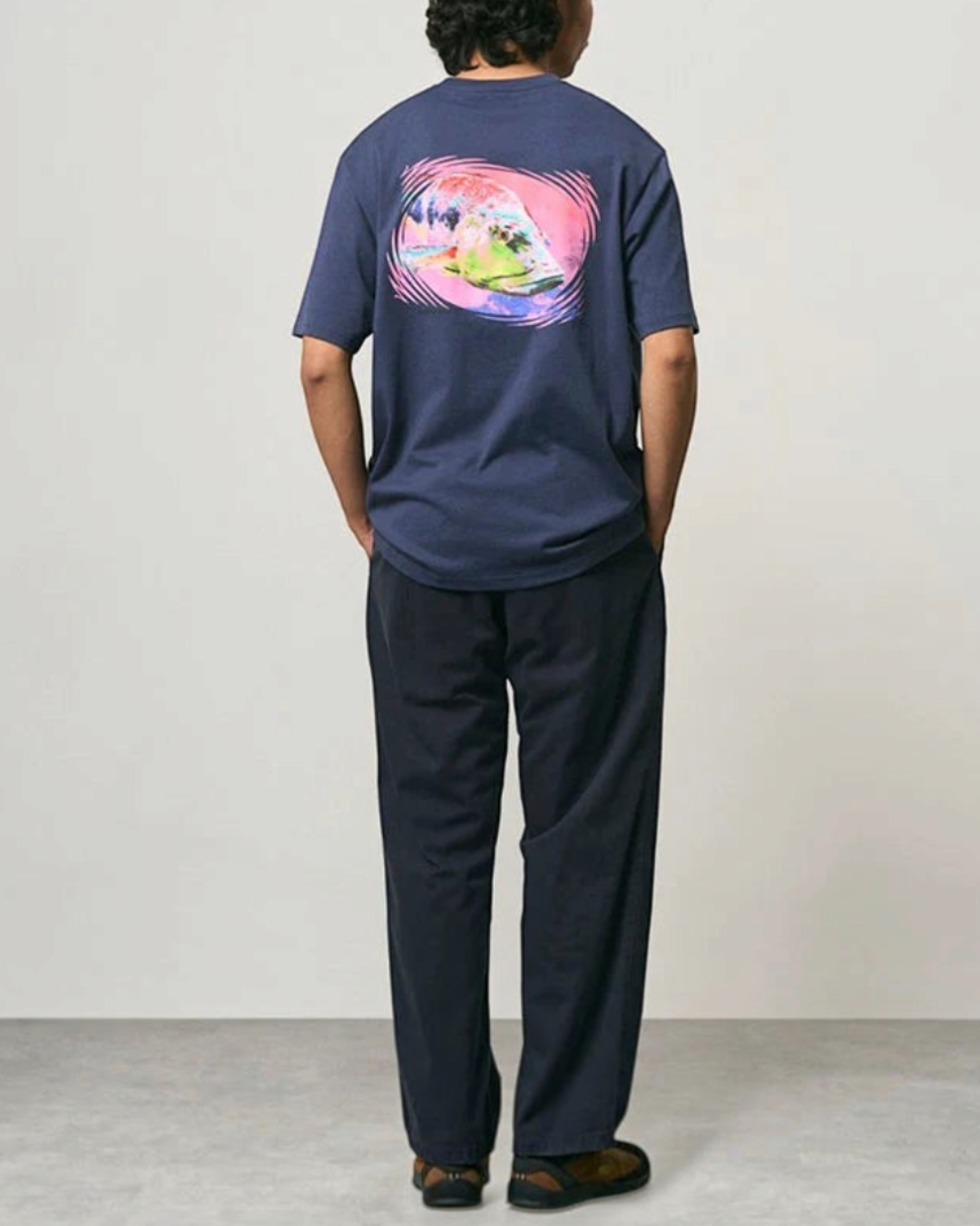 Homme portant un pantalon droit bleu marine Merci Paris Gramicci en coton avec un t-shirt graphique au dos