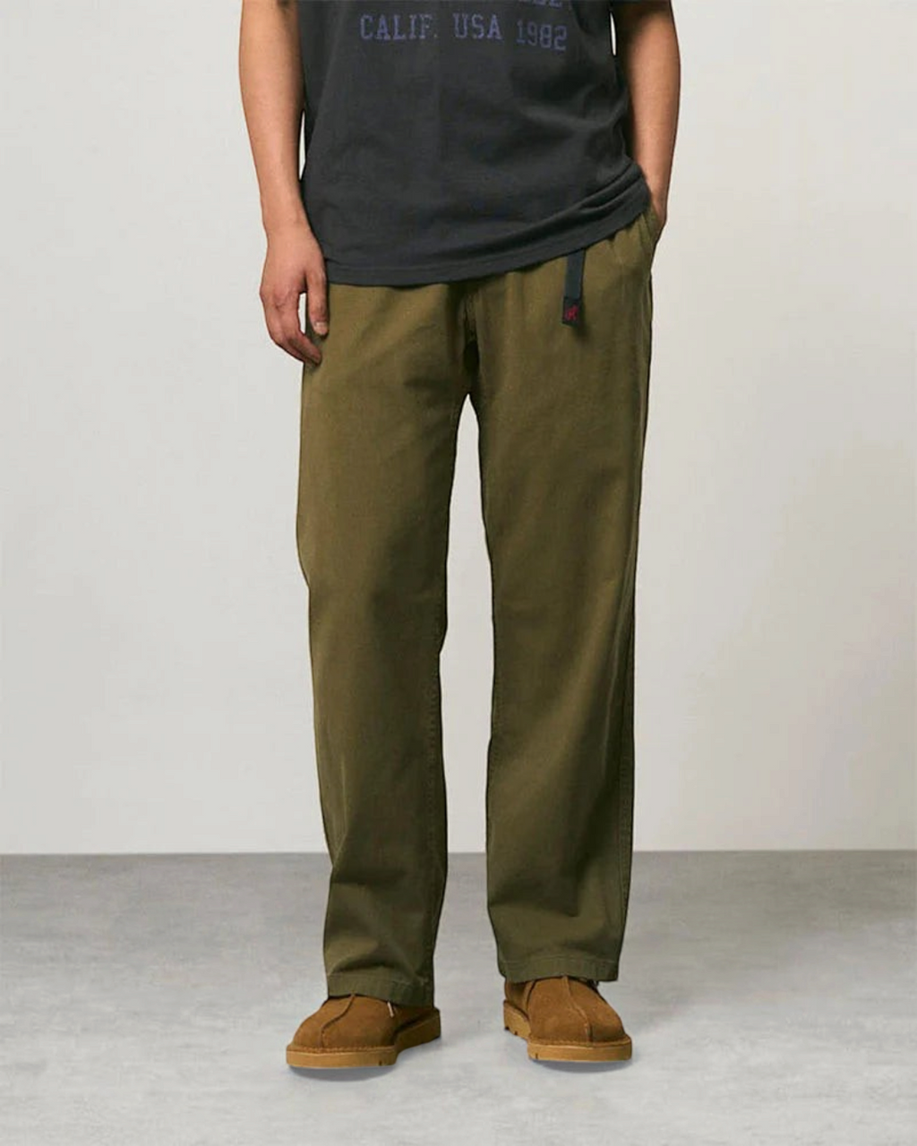 Pantalon droit Gramicci en sergé de coton olive avec ceinture intégrée, porté par un homme, collection Merci Paris
