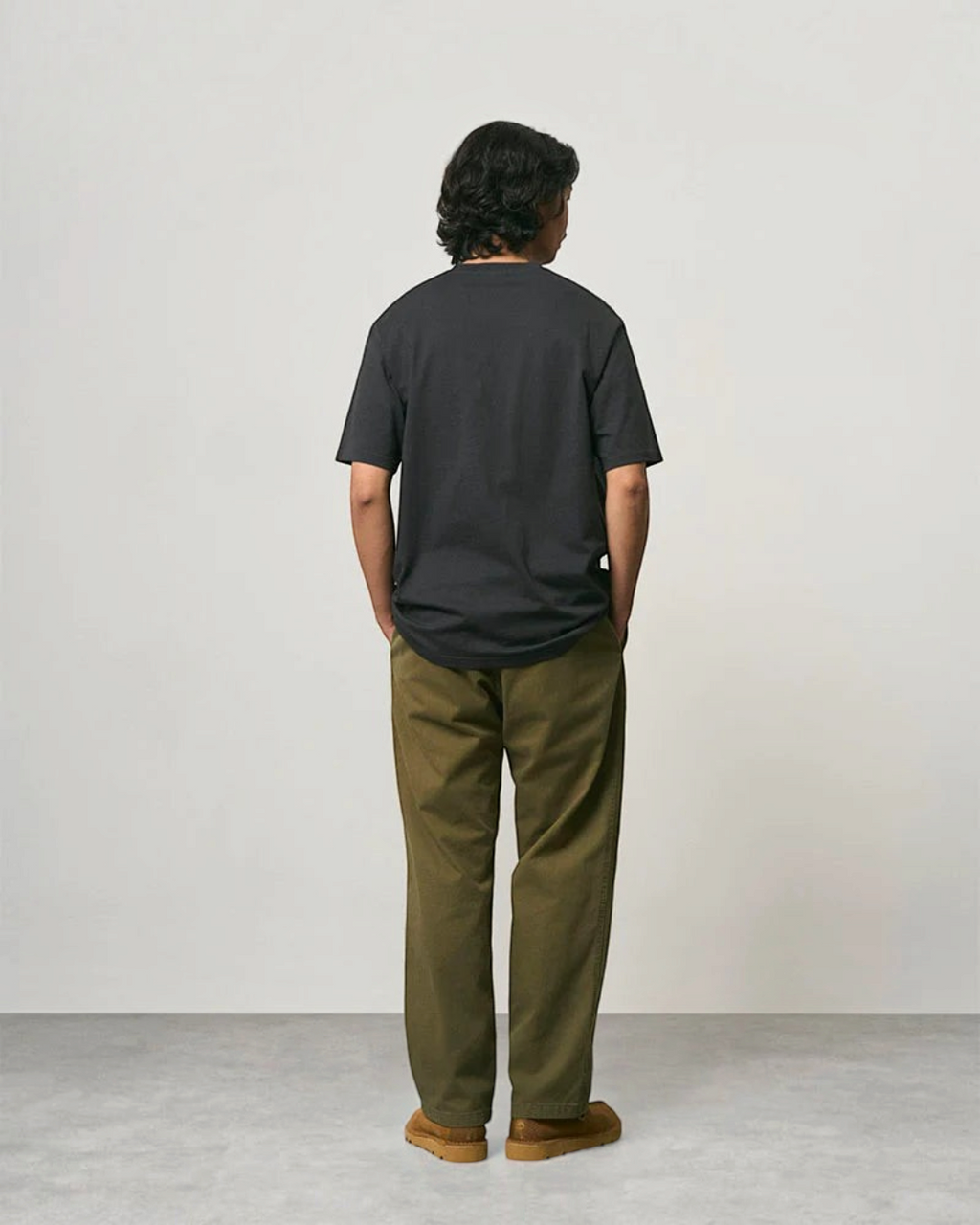 Homme portant un pantalon droit Gramicci olive en coton sergé avec une coupe décontractée, vue de dos, Merci Paris
