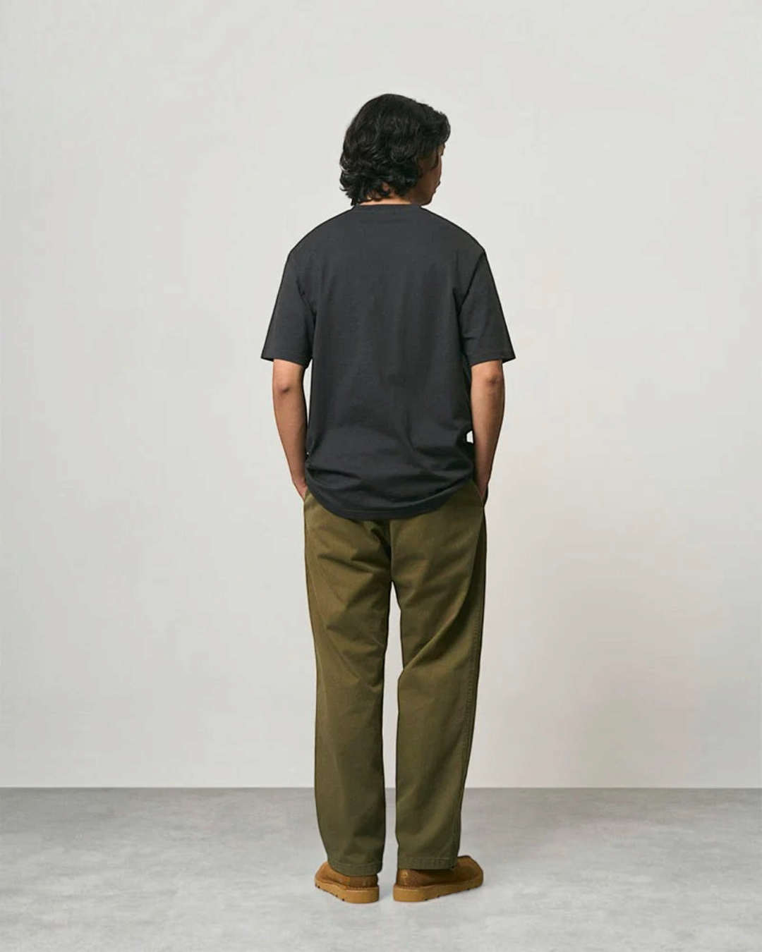 Homme portant un pantalon droit Gramicci olive en coton sergé avec une coupe décontractée, vue de dos, Merci Paris
