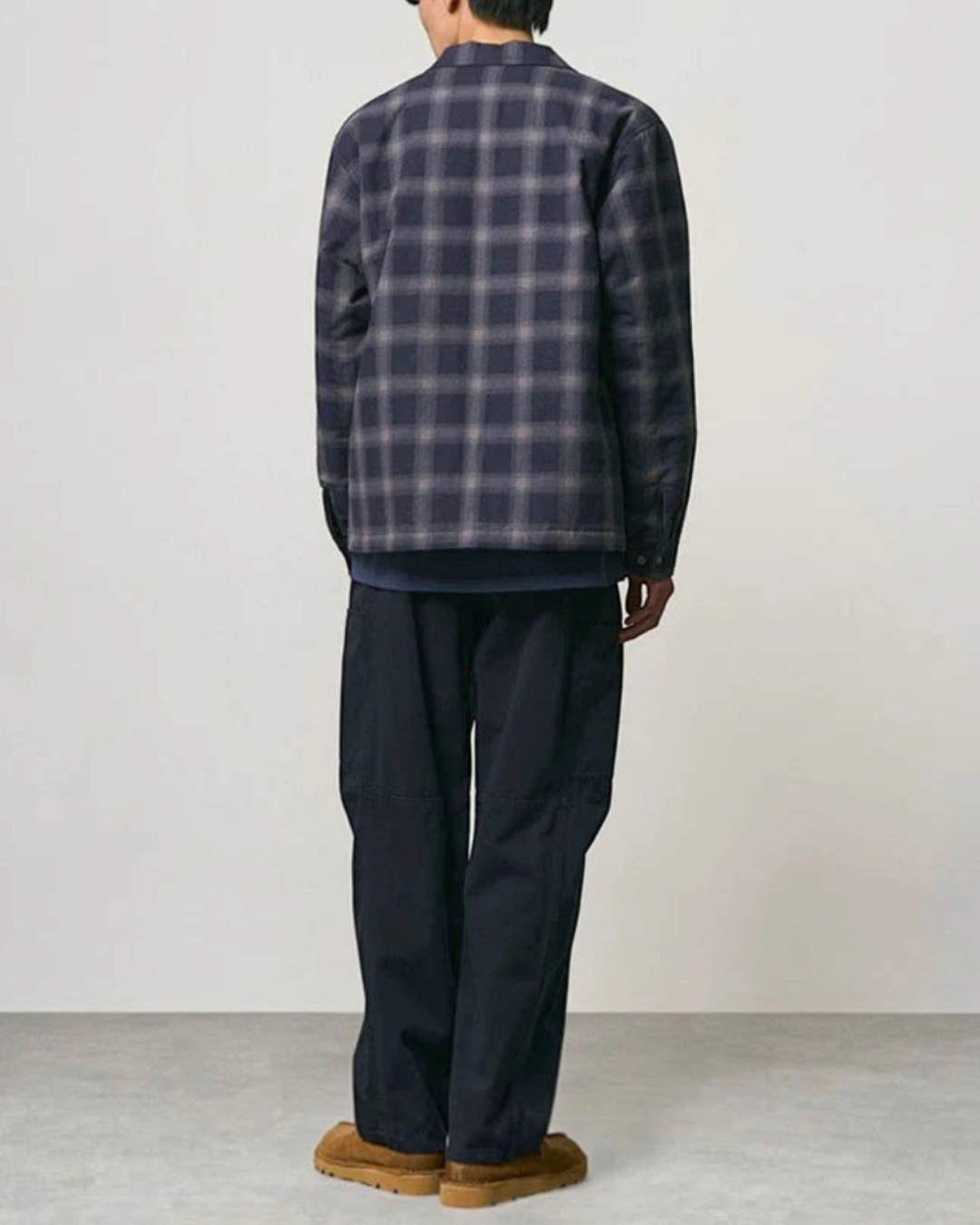 Homme portant le pantalon Voyageur bleu marine Gramicci de Merci Paris avec une chemise à carreaux et des chaussures