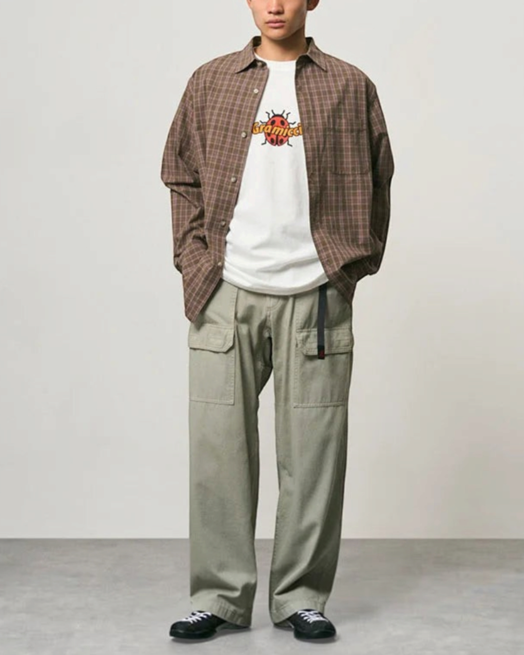 Homme portant une chemise épaisse à carreaux violets Gramicci ouverte sur un t-shirt blanc, Merci Paris