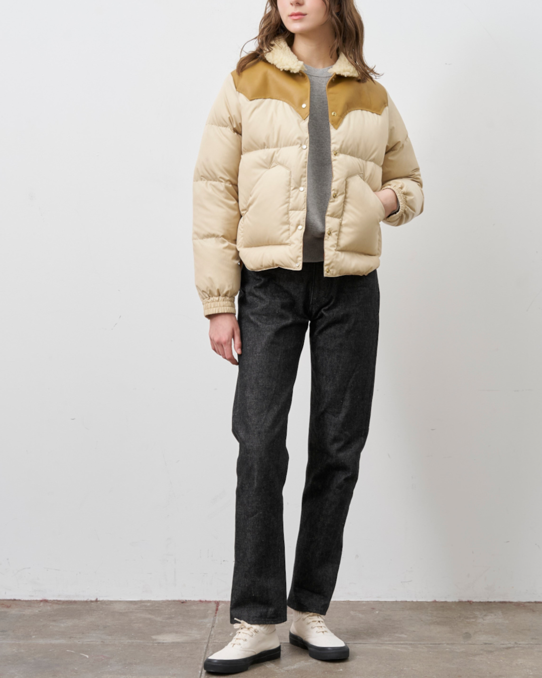 Modèle portant la veste beige Kourtney de Merci Paris avec empiècement en cuir et garnissage en duvet isolant