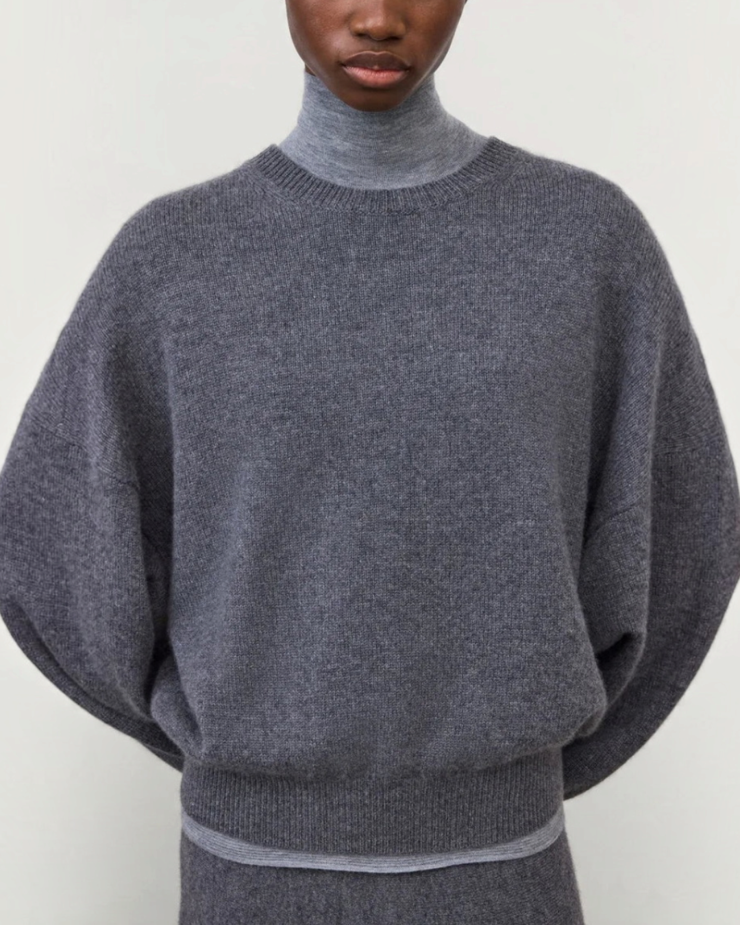 Pull Veira en cachemire gris graphite Merci Paris avec col rond et manches tombantes porté par une mannequin