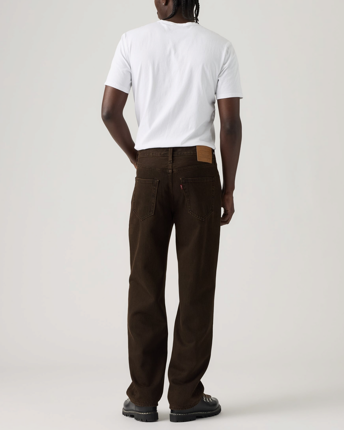 Homme portant un jean Levi's 568 Loose Straight marron en coton avec un t-shirt blanc, vue de dos, style décontracté.