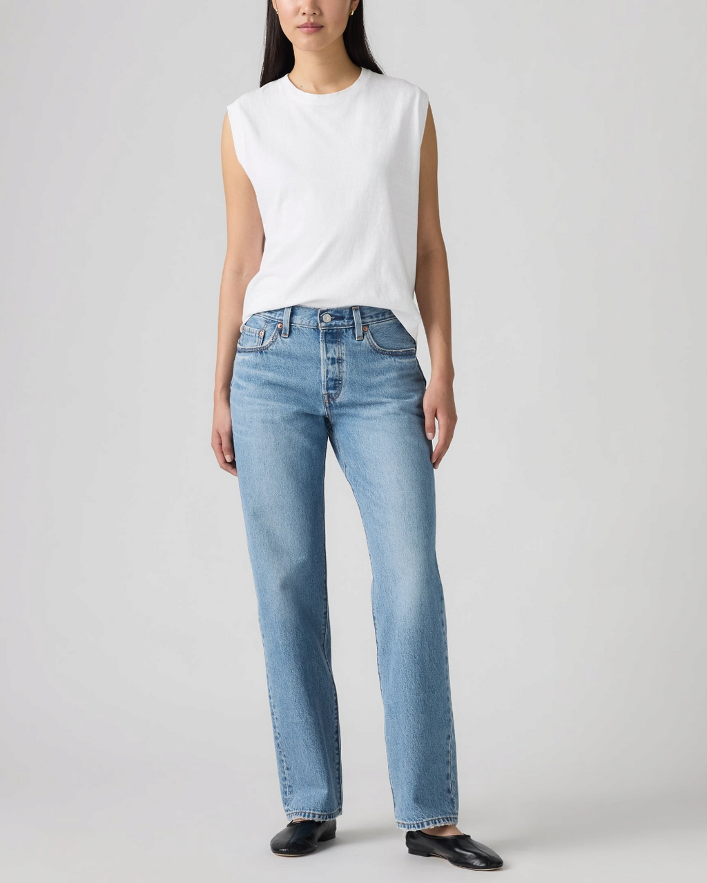 Modèle portant le jean Levi's 501 '90 bleu clair coupe droite Merci Paris avec un débardeur blanc