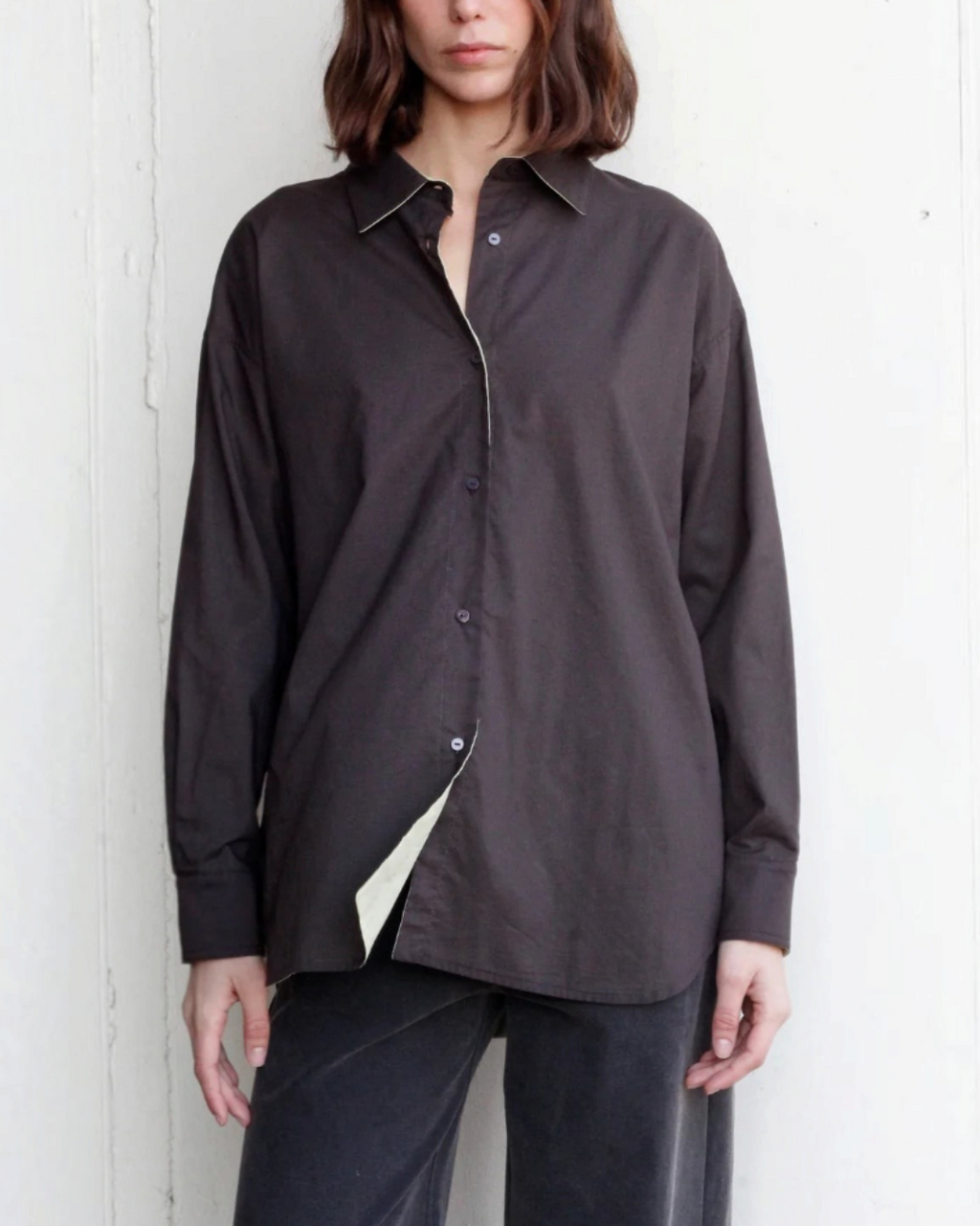 Chemise réversible Merci Paris en coton biologique marron foncé, coupe oversize portée par une femme