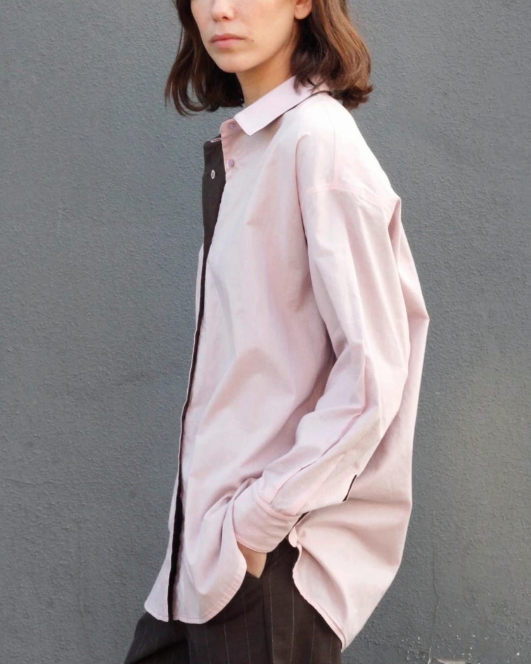 Mannequin portant la chemise réversible Merci Paris en coton biologique rose et marron, coupe oversize