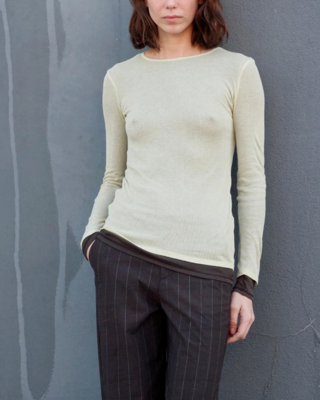 Mannequin portant le haut réversible Merci Paris Hamburg en Tencel vert doux à manches longues et coupe ajustée