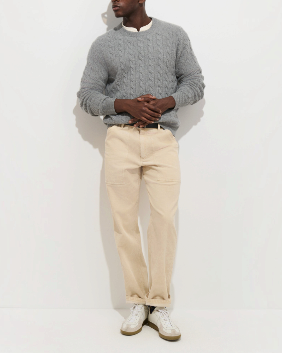 Homme portant un pantalon Painter Merci Paris Alex Mill en velours côtelé beige oatmeal avec un pull gris torsadé