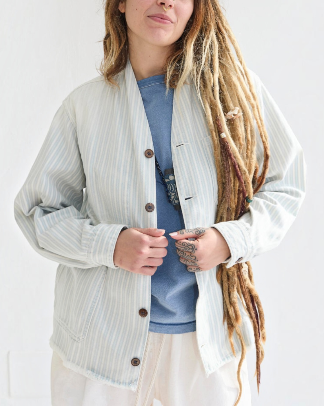 Modèle portant la veste Okinawa Merci Paris en coton rayé bleu et écru, coupe kimono décontractée avec boutons coco
